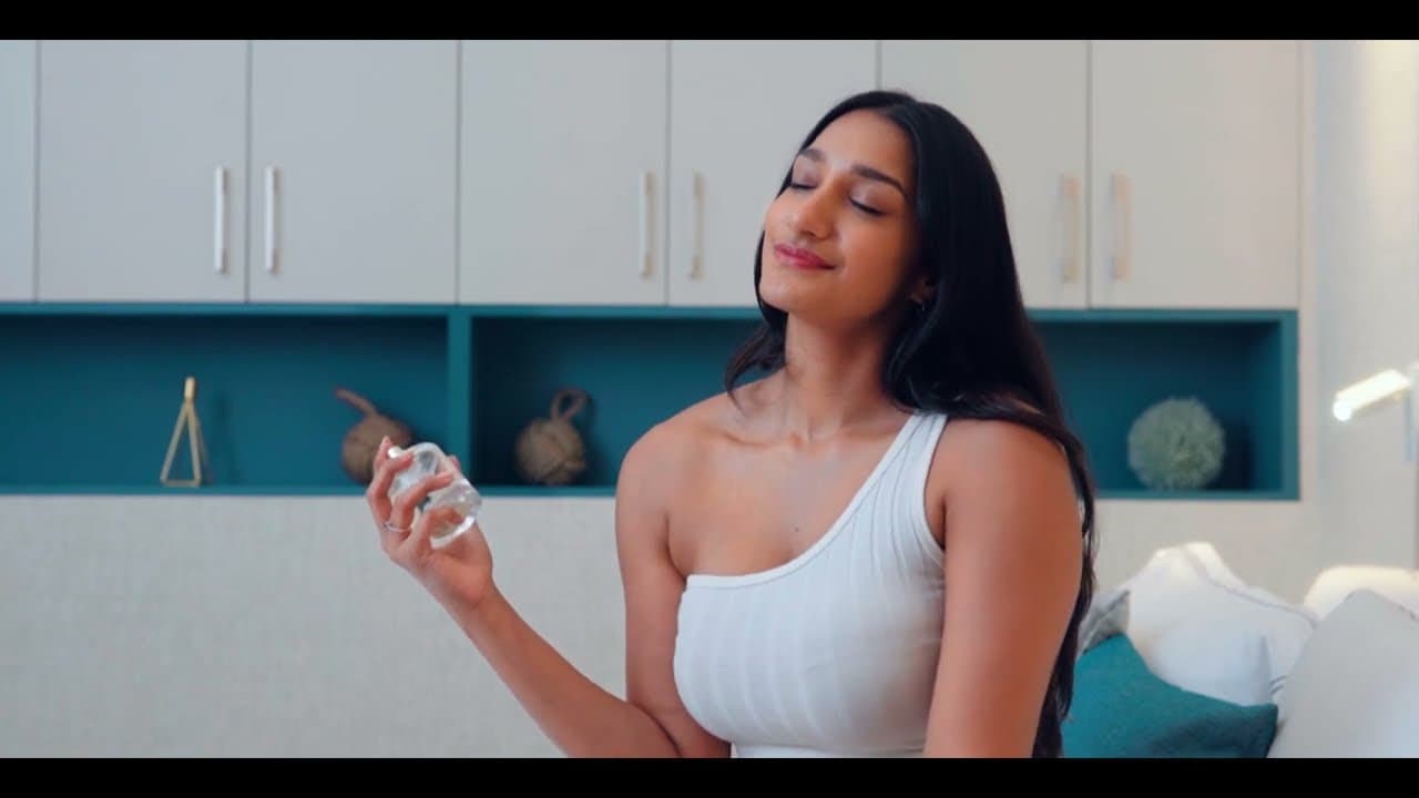 Model applying fragrance in a bright kitchen, from the Exclusive Lines launch film